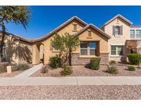 Inviting single-story home showcasing a stone facade and manicured landscaping at 9062 W Nicolet Ave, Glendale, AZ 85305