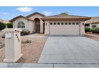 Charming single-story home with a desert landscape and a spacious two-car garage at 9437 E Champagne Dr, Sun Lakes, AZ 85248