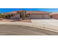 Charming single-story home featuring a three-car garage, tile roof, and desert landscaping at 11525 E Laguna Azul Cir, Mesa, AZ 85209