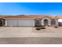 Charming single-story home featuring a three-car garage, desert landscaping and a red tile roof at 1470 S Villas Ct, Chandler, AZ 85286