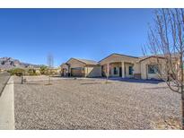 Desert home with a circular gravel driveway, three car garage and mountain views at 1727 E Hidalgo St, Apache Junction, AZ 85119