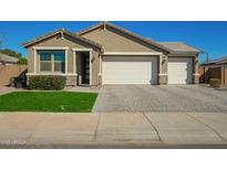 Charming single-story home with a well-manicured lawn and a spacious three-car garage at 18006 W Hess St, Goodyear, AZ 85338