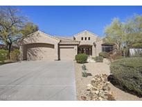 Charming single-story home featuring desert landscaping, a three-car garage, and a welcoming front entrance at 28604 N 92Nd Pl, Scottsdale, AZ 85262