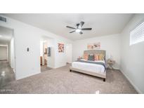 This bedroom offers a ceiling fan and an ensuite bathroom for convenience at 7928 N 46Th Ave, Glendale, AZ 85301