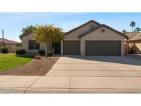 Charming single-story home with a well-manicured lawn, mature landscaping, and a two-car garage at 804 N Jamaica Way, Gilbert, AZ 85234