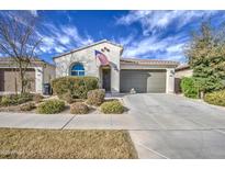 Charming single-story home with desert landscaping, a two-car garage, and an American flag at 9818 E Talon Ave, Mesa, AZ 85212