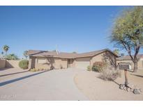 Charming home featuring a driveway, attached garage, and desert landscaping under a bright blue sky at 13134 N 20Th Ave, Phoenix, AZ 85029