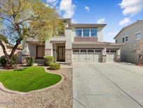 Inviting two-story home featuring a three-car garage and manicured front lawn at 14425 N 137Th Ln, Surprise, AZ 85379