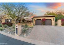 Charming home exterior with a paver driveway, mature desert landscaping, and a two-car garage at 18683 N 101St Pl, Scottsdale, AZ 85255