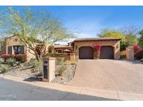 Charming single-story home featuring a terracotta roof, brick driveway and mature desert landscaping at 18683 N 101St Pl, Scottsdale, AZ 85255