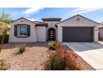 Charming single-story home featuring a well-manicured landscape, inviting entrance, and attached two-car garage at 19919 W Harrison St, Buckeye, AZ 85326