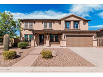 Inviting two-story home featuring a well-manicured yard and attached two-car garage at 7910 W Spur Dr, Peoria, AZ 85383