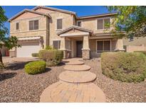 Two-story home with brick walkway, desert landscaping, and a two car garage at 9382 W Louise Dr, Peoria, AZ 85383