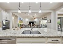 Open kitchen view, showcasing granite counters, stainless steel sink, and spacious open layout to living areas at 10049 E Topaz Ave, Mesa, AZ 85212