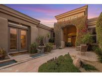 Stunning front entrance features a stone path, beautiful flowers, and elegant architecture at 10886 E Ludlow Dr, Scottsdale, AZ 85255