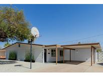 Charming single-story home featuring a basketball hoop, carport, and freshly painted exterior at 12207 N Escobar Way, Phoenix, AZ 85022