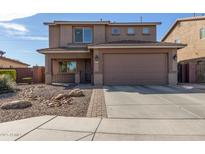 Inviting two-story home featuring a well-maintained yard with desert landscaping and an attached two-car garage at 1329 W Crape Rd, Queen Creek, AZ 85140