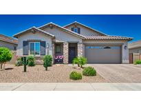Charming single-story home showcasing a well-manicured front yard with desert landscaping and neutral color palette at 15262 W Garfield St, Goodyear, AZ 85338