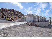 Desert home with a desert landscape, featuring a long driveway and a spacious two-car garage at 27145 N 147Th Ave, Surprise, AZ 85387