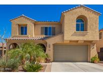 Inviting two-story home with a tan stucco exterior, arched windows, and a well-maintained front yard at 3103 S Dakota Pl, Chandler, AZ 85248