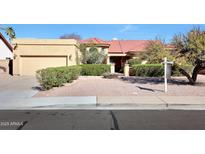 Charming single-story home featuring a well-maintained front yard with mature landscaping and a red-tile roof at 4080 W Orchid Ln, Chandler, AZ 85226