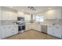 Bright kitchen features white cabinets, stainless steel appliances, and tile backsplash at 6808 W Sierra St, Peoria, AZ 85345