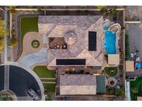 Stunning aerial view of a custom home with a pool, spa, fire pit, and lush landscaping at 7157 E Ivyglen Cir, Mesa, AZ 85207