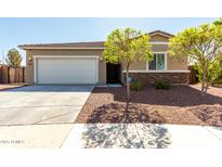 Charming single-story home showcasing a two-car garage, desert landscaping, and stone accents at 101 W Seven Seas Dr, Casa Grande, AZ 85122