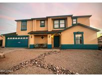 Charming two-story home featuring colorful trim, a covered porch, and a rock-lined walkway at 11429 W Cabrillo Dr, Arizona City, AZ 85123