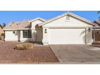 Charming single-story home featuring a well-maintained front yard and a two-car garage at 11951 N 69Th Ave, Peoria, AZ 85345