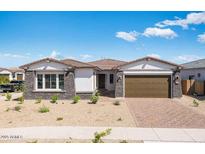 Beautiful single-story home featuring a brick driveway, well-kept landscape and attached two car garage at 14194 W Sand Hills Rd, Surprise, AZ 85387