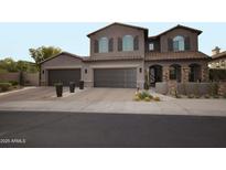 Elegant two-story home featuring a three-car garage and desert landscaping at 17594 N 98Th Way, Scottsdale, AZ 85255