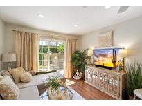 Bright living room features hardwood floors, a cozy couch, and sliding glass doors at 4800 N 68Th St # 263, Scottsdale, AZ 85251