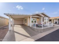 Charming home with a covered carport and cozy front porch, perfect for relaxing at 650 N Hawes Rd # 2873, Mesa, AZ 85207