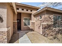 Inviting single-story home with a stylish mix of stucco and stone exterior accents, plus a covered front entrance at 8962 W Grovers Ave, Peoria, AZ 85382