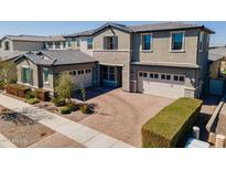 A charming two-story home with a brick driveway and two-car garage, enhanced by beautiful landscaping at 9960 E Strobe Ave, Mesa, AZ 85212