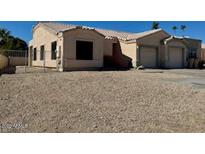 Tan single-story home with a two-car garage, a low-pitched roof, and desert landscaping at 14216 N Saguaro Blvd # A, Fountain Hills, AZ 85268
