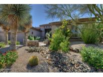 Inviting desert landscaping with a dry riverbed and mature plants adds curb appeal to this home's front yard at 9671 E Cavalry Dr, Scottsdale, AZ 85262