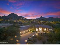 Stunning desert home featuring beautiful stone driveway, three-car garage and mountain views at sunset at 10379 E White Feather Ln, Scottsdale, AZ 85262