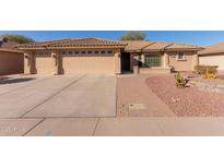 Charming single-story home featuring a three-car garage and a well-maintained desert landscaped front yard at 11034 E Natal Ave, Mesa, AZ 85209