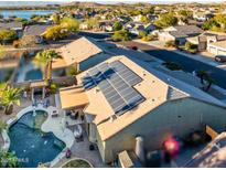 Stunning aerial view of backyard featuring a beautiful pool and solar panels on the roof at 11182 S Hopi Dr, Goodyear, AZ 85338