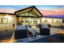 The modern home has a large patio furnished with sophisticated outdoor seating, perfect for entertaining and relaxation at 12201 N 65Th St, Scottsdale, AZ 85254