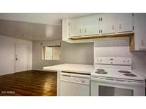 Bright kitchen features white cabinetry, an island, and modern appliances at 12221 W Bell Rd # 249, Surprise, AZ 85378