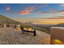 Desert property with a fire feature and sunset views from a brick patio and surrounding hills at 14675 E Paradise Dr, Fountain Hills, AZ 85268