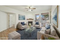 Bright living room features a fireplace, ceiling fan, modern furnishings, and shuttered windows at 1747 E Northern E Ave # 166, Phoenix, AZ 85020