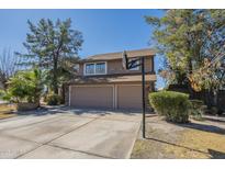 Two-story home featuring a two-car garage, basketball hoop and low maintenance landscaping at 18194 N 59Th Ln, Glendale, AZ 85308