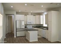 Bright kitchen featuring white cabinets, stainless steel appliances, and a functional center island at 2206 S Ellsworth Rd # 14 B, Mesa, AZ 85209