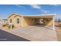 Charming single-story home with a spacious carport and well-maintained landscaping and light yellow painted wood and stucco at 40569 N Wedge Dr, San Tan Valley, AZ 85140