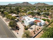 Stunning aerial view of a modern home with a pool, pristine landscaping, and mountain views at 9900 N 52Nd St, Paradise Valley, AZ 85253