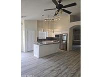 Bright kitchen featuring a center island, stainless steel appliances, and modern lighting fixtures at 11318 S Hopi Dr, Goodyear, AZ 85338